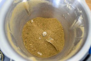 getrocknete Pilze, Steinpilze, Kräuter, Zwiebel, Lorbeerblatt und Petersilie in der Küchenmaschine mahlen