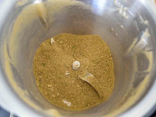 getrocknete Pilze, Steinpilze, Kräuter, Zwiebel, Lorbeerblatt und Petersilie in der Küchenmaschine mahlen