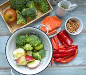 geputzter Brokkoli, Äpfel, Paprika, Nüsse für Rohkostsalat