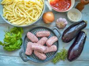 Zutaten Salsiccia, Pasta, Tomatensauce, Auberginen, Knoblauch und Zwiebel