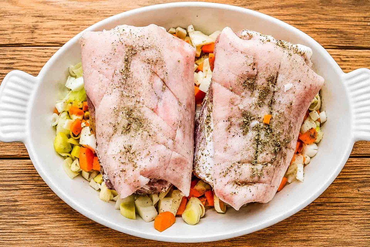 Schweinshaxe mit Gewürzen und Röstgemüse in der Auflaufform