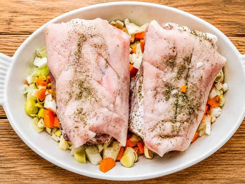 Schweinshaxe mit Gewürzen und Röstgemüse in der Auflaufform