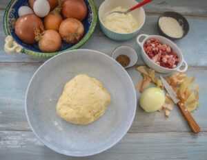Zutaten Hefeteig, Eier, Speck, Zwiebeln, saure Sahne, Salz Pfeffer Kümmel