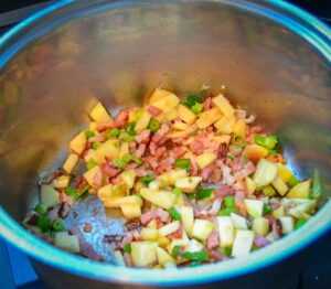 Äpfel, Bacon, Schalotte und Lauchzwiebel anbraten für die Schalentiere