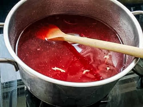 Gelee im Topf kochen und mit Holzlöffel rühren