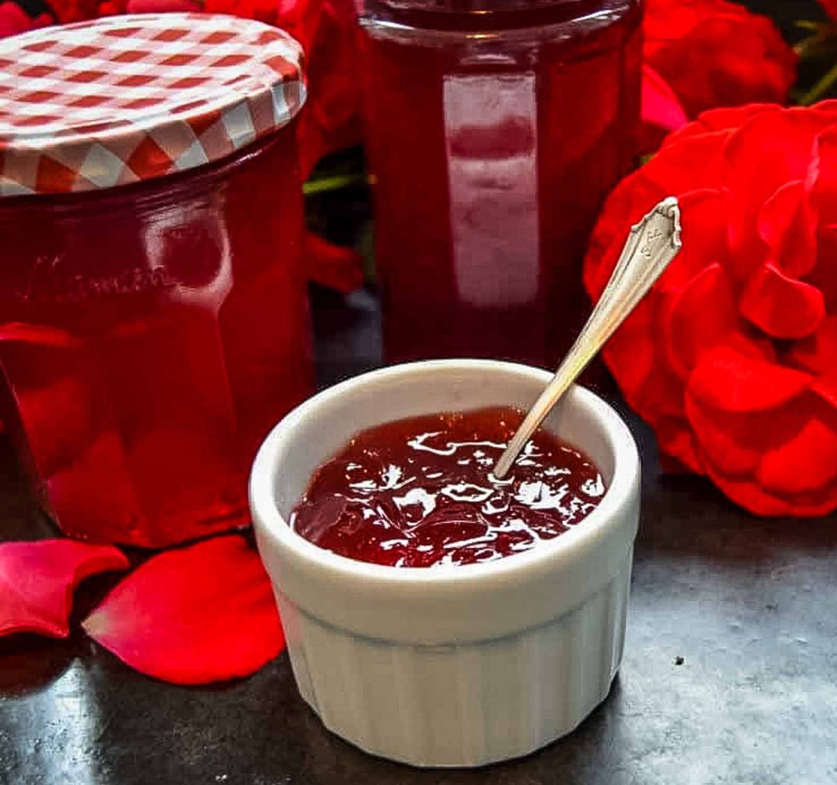 Rosengelee, Rosenmarmelade im Marmeladenglas und abgefüllt in weißem Porzellanschälchen mit Löffel