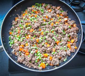 ackfleisch, Karotten, Zwiebel, Erbsen und Knoblauch braten