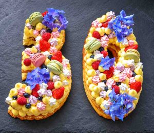 Zahlentorte Number Cake Geburtstagstorte mit Biskuit, Mürbeteig, Vanillecreme, dekoriert mit Macaron Beerenfrüchten, und Blüten