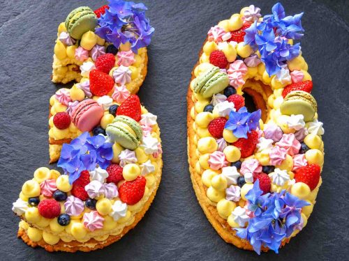 Zahlentorte Number Cake Geburtstagstorte mit Biskuit, Mürbeteig, Vanillecreme, dekoriert mit Macaron Beerenfrüchten, und Blüten
