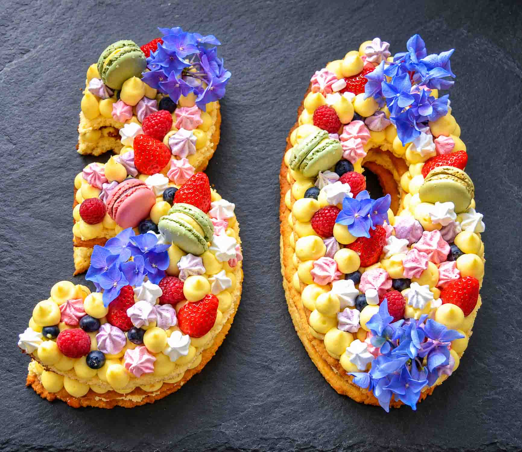 Zahlentorte Number Cake Geburtstagstorte mit Biskuit, Mürbeteig, Vanillecreme, dekoriert mit Macaron Beerenfrüchten, und Blüten