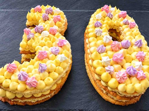 Zahlentorte Number Cake Geburtstagstorte mit Biskuit, Mürbeteig, Vanillecreme, dekoriert mit Macaron Beerenfrüchten, und Blüten
