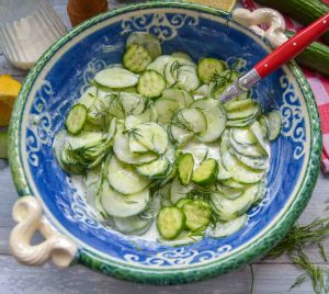 Gurkensalat mit Sahne wie von Oma in blauer Schüssel mit Löffel