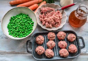 Hackfleischbällchen mit Erbsen und Möhren