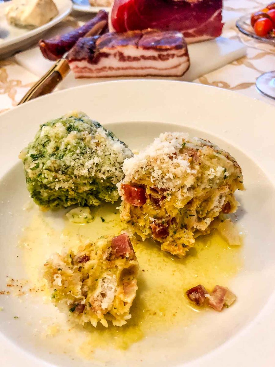 Tiroler Speckknödel und Spinatknödel mit brauner ausgelassener Butter und geriebenen Parmesan