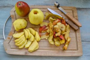Äpfel schälen und in Spalten und Ringe schneiden