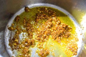 Ingwer und Currypaste in Kokosöl braten