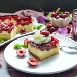 Kirsch Schmandkuchen mit Sahne auf weißem Teller