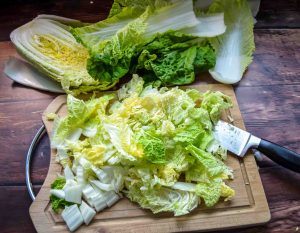 Chinakohl halbieren, vierteln und in Streifen schneiden