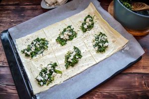 ausgerollter Blätterteig mit Spinatfüllung und Feta