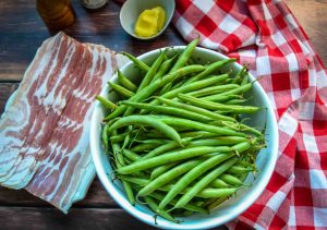 Zutaten grüne Bohnen, Speck und Butter zum Braten