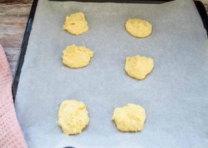 6 Teighäufchen auf einem mit Backpapier ausgelegtem Blec