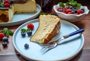 cremiger spanischer Cheesecake auf blauem Teller mit Beeren