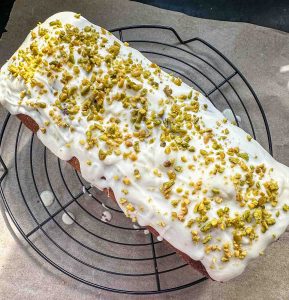 Kürbiskuchen mit weißer Glasur und gehackten Pistazienkernen