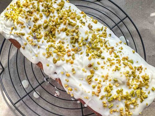 Kürbiskuchen mit weißer Glasur und gehackten Pistazienkernen