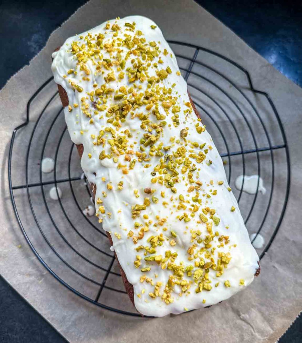 Kürbiskuchen mit weißer Glasur und gehackten Pistazien