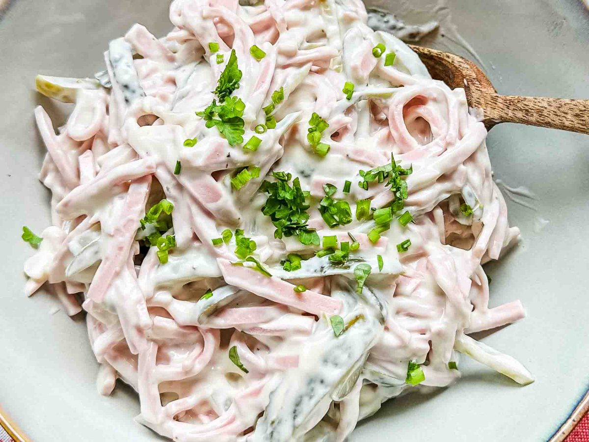 Cremiger Fleischsalat mit Schnittlauchröllchen in einer kleinen Schüssel