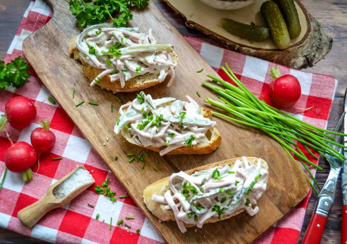 cremiger Fleischsalat auf Baguettescheibe mit Schnittlauchröllchen