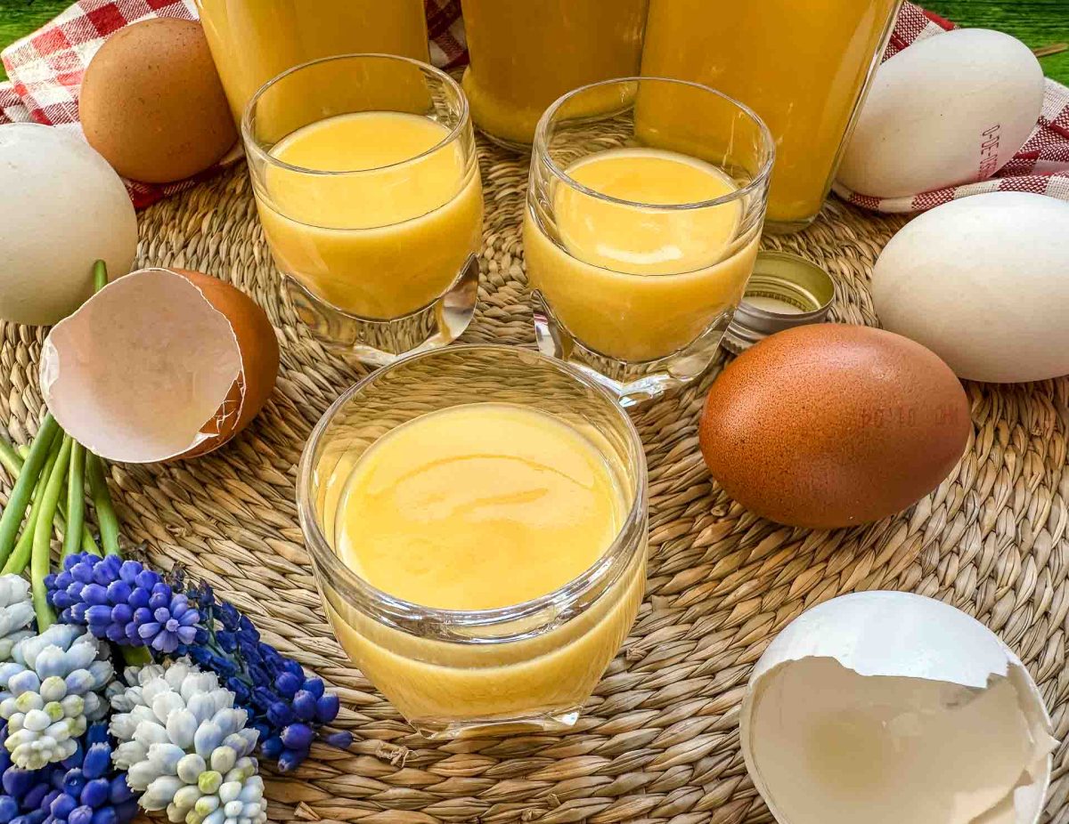 Selbstgemachter Eierlikör im Glas und in kleinen Flaschen angerichtet