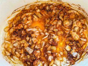 Zwiebelwürfel in Schweineschmalz in einem Bräter, mit Paprikapulver anbraten