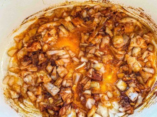 Zwiebelwürfel in Schweineschmalz in einem Bräter, mit Paprikapulver anbraten