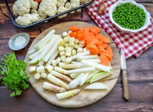 Frisches Frühlingsgemüse kleingeschnitten, mit Möhre, Spargel, Kohlrabi, Erbsen, Petersilie und Blumenkohl