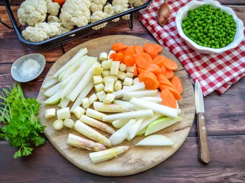 Frisches Frühlingsgemüse kleingeschnitten, mit Möhre, Spargel, Kohlrabi, Erbsen, Petersilie und Blumenkohl