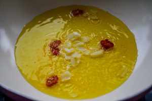 Knoblauch und Chili in Olivenöl braten