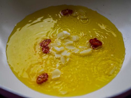Knoblauch und Chili in Olivenöl braten