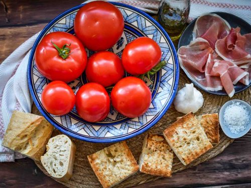 Zutaten, geröstetes Brot, Tomate, Olivenöl, Knoblauch und Serano Schinken