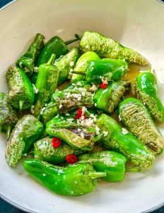 in der Pfanne gebratene Pimientos de padron mit gehacktem Knoblauch , Olivenöl und roter Chili