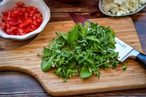 Frische Kräuter, Oregano, Minze, Tyhmian, Rosmarin, Bohnenkaut und Petersilie hacken