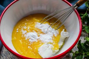 Zitronenpudding mit Quark in Rührschüssel mit dem Schneebesen verrühren