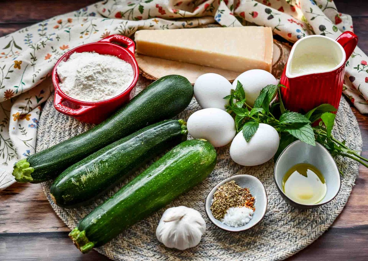 Zutaten Zucchiniquiche, Eier, Parmesan, Minze, Mehl, Sahne, Gewürze und Zucchini